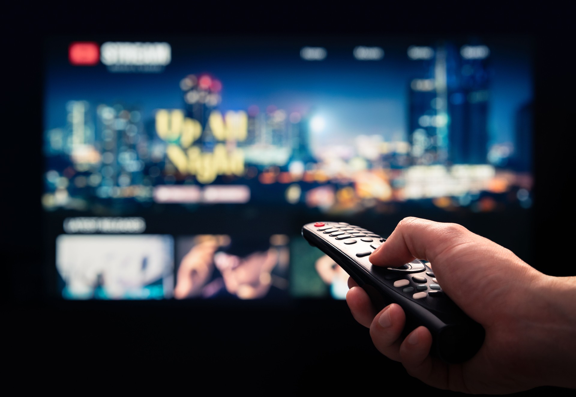 Watching movie stream service on tv. Video on demand subscription service and platform in television. Streaming series, films and shows online. Man using remote control.